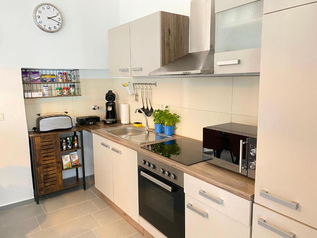 a kitchen with a sink and a stove top oven at Schulz Apartments in Bonn
