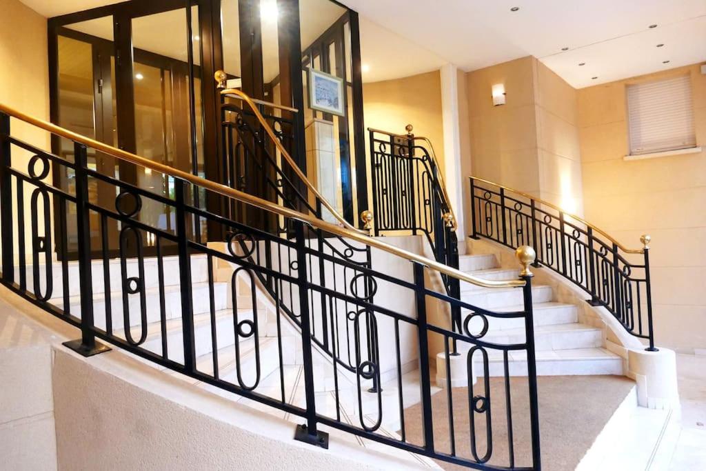 a staircase with black railings in a building at ❀ Disneyland Paris, Résidence Privée dans Centre ❀ in Chessy