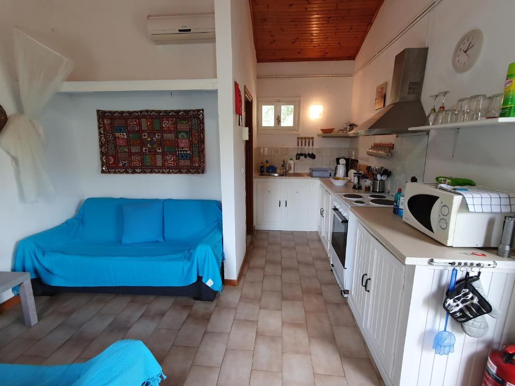 kuchnia z niebieską kanapą w pokoju w obiekcie Villa Stephanie w mieście Paleokastritsa