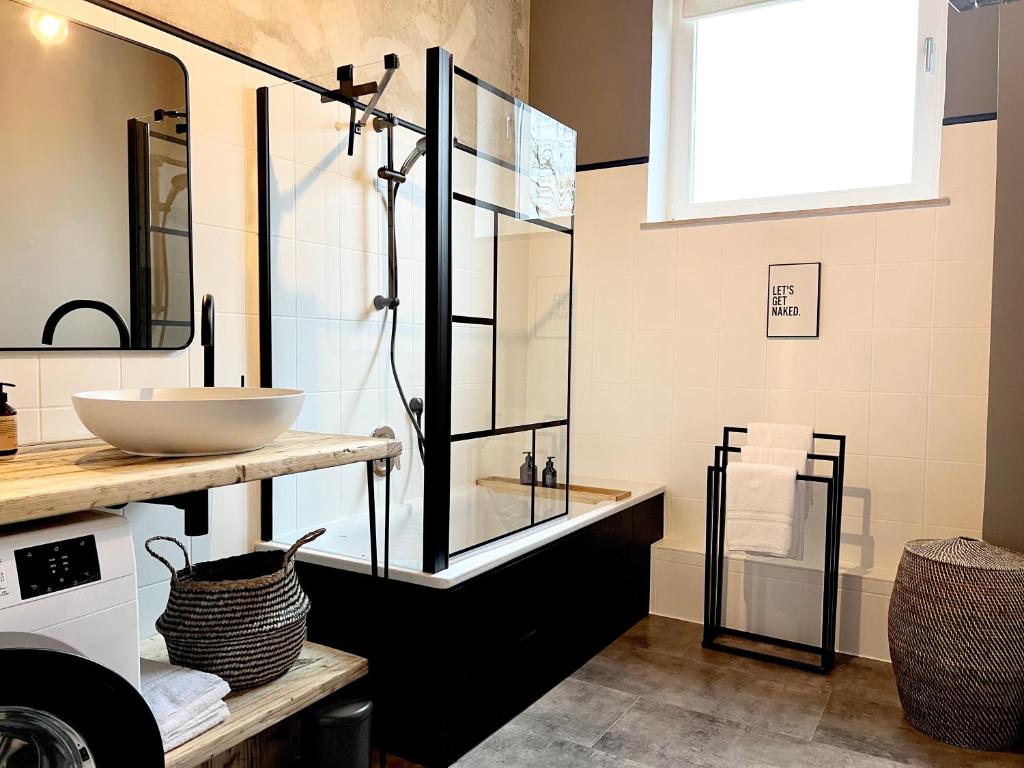 La salle de bains est pourvue d'un lavabo et d'une douche en verre. dans l'établissement MAKERS + ROOMS APARTMENTS, à Detmold