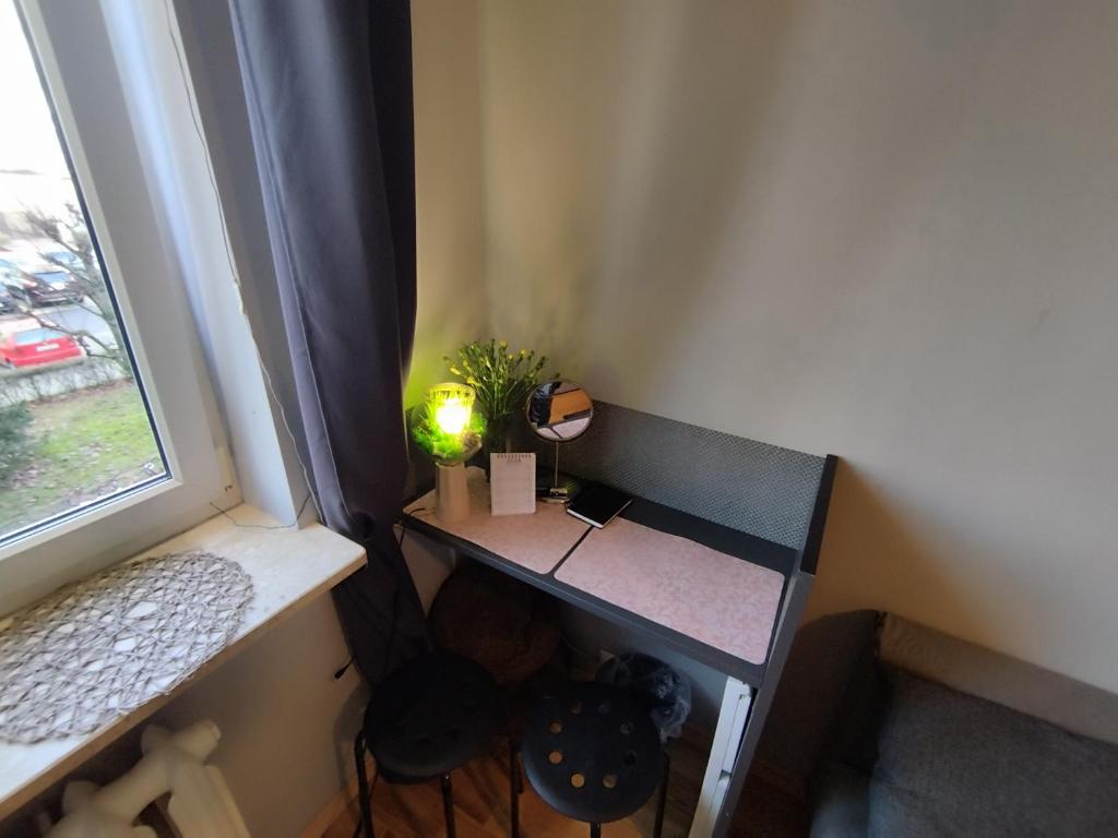 a small desk in a room with a window at Niewielki pokój dla jednej osoby lub pary. in Warsaw