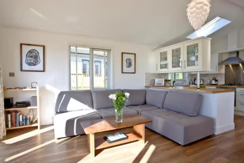uma sala de estar com um sofá e uma mesa em Salcombe Retreat Lodge 2 em Soar