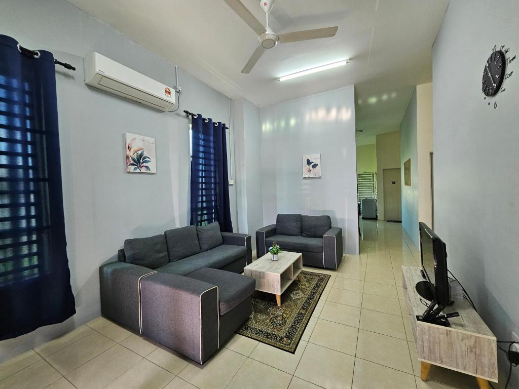 - un salon avec deux canapés et une télévision dans l'établissement Homestay Uni, Kuala Kedah, à Kuala Kedah