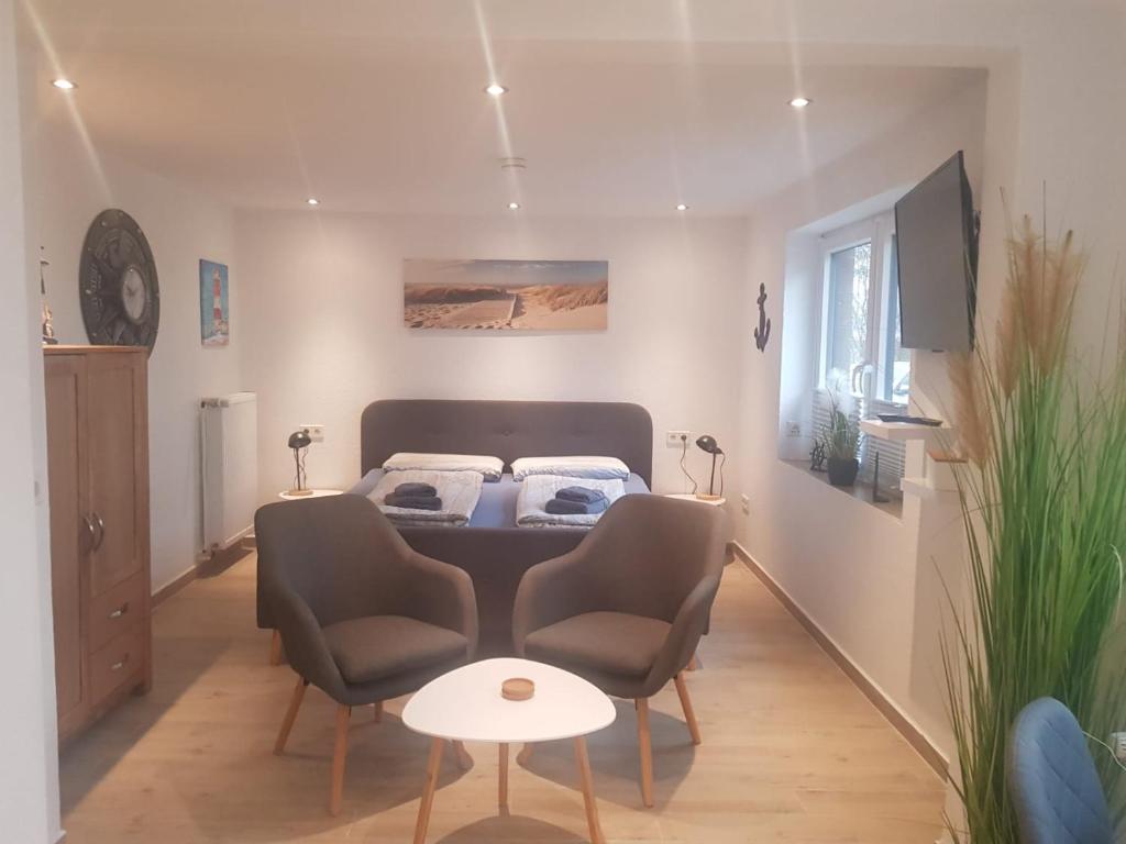 1 Schlafzimmer mit einem Bett, 2 Stühlen und einem Tisch in der Unterkunft Apartmenthaus Westerkoog in Hedwigenkoog