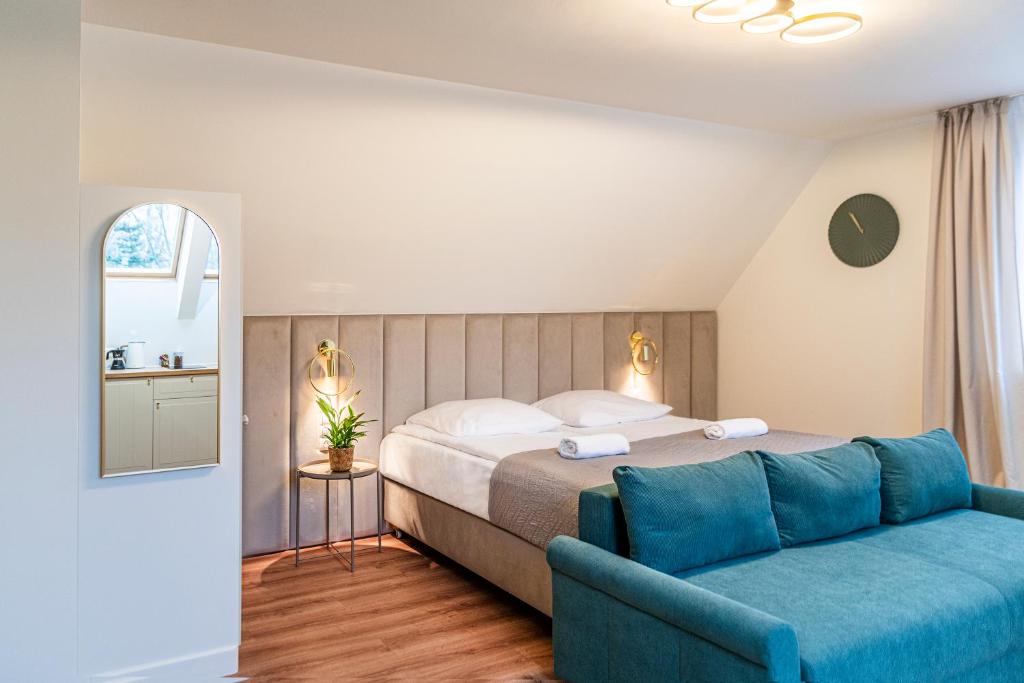 a bedroom with a bed and a blue couch at Willa Lapwing in Sopot