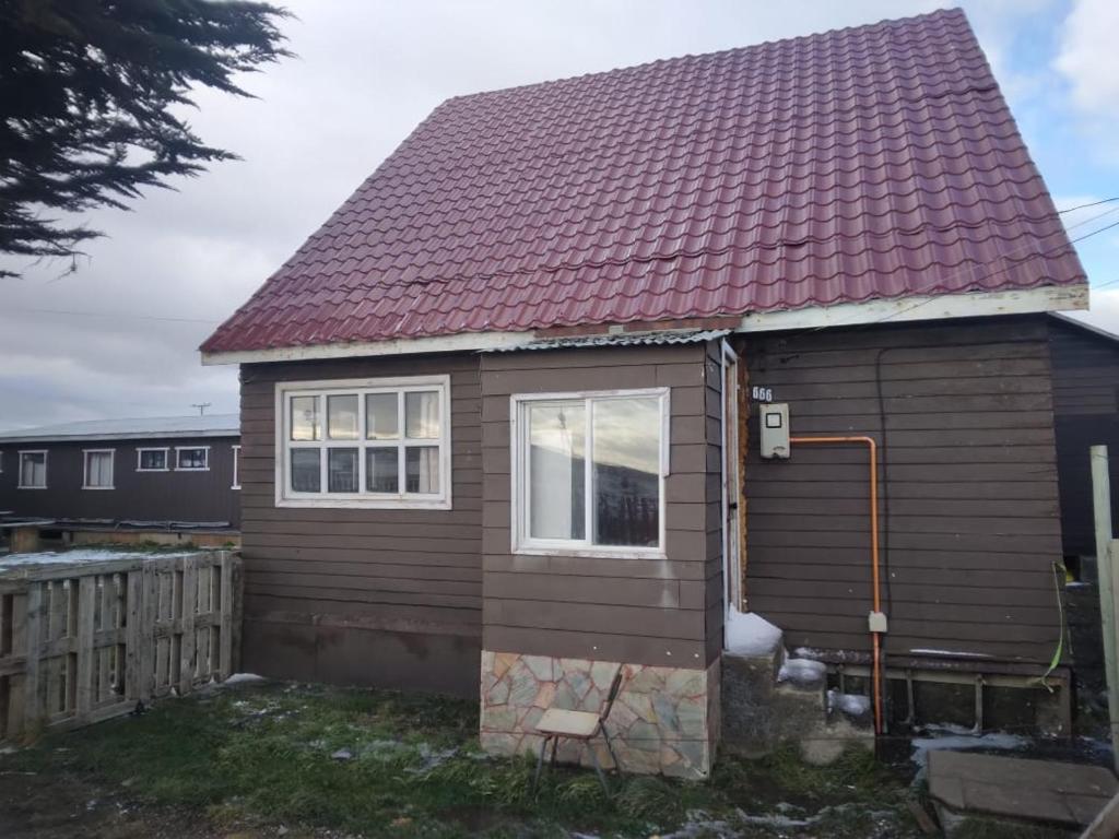 una pequeña casa con techo rojo en Refugio 644 en Porvenir