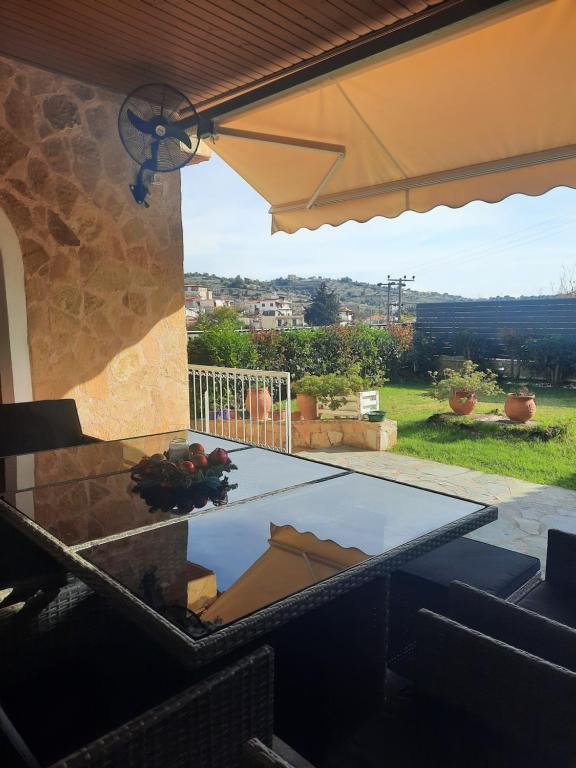 Blick auf eine Terrasse mit einem Tisch und einem Sonnenschirm in der Unterkunft Marathon VS LUXURY VILLA in Grammatiko