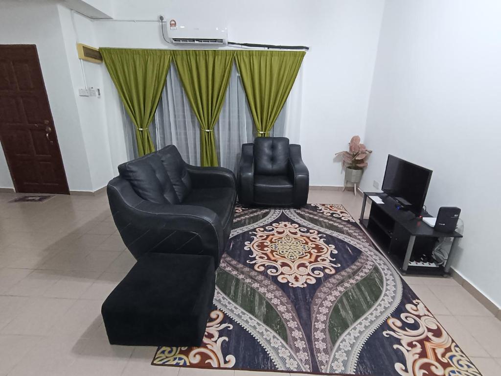 two chairs and a rug in a living room at Fausal Legacy Homestay Sungai Besar in Sungai Besar