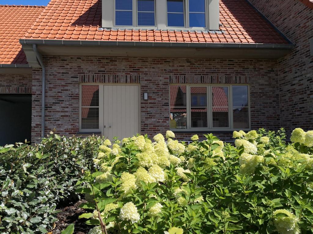 a house with a bunch of bushes in front of it at Newport House in Nieuwpoort