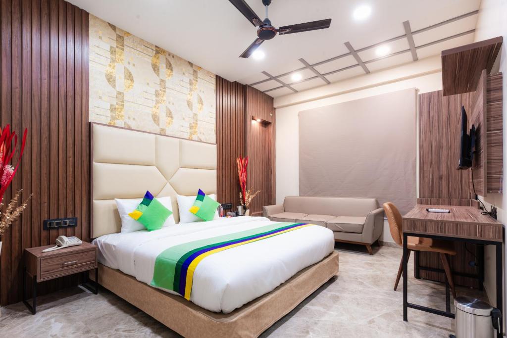 a bedroom with a king sized bed and a desk at Treebo Trend City Center in Nagpur
