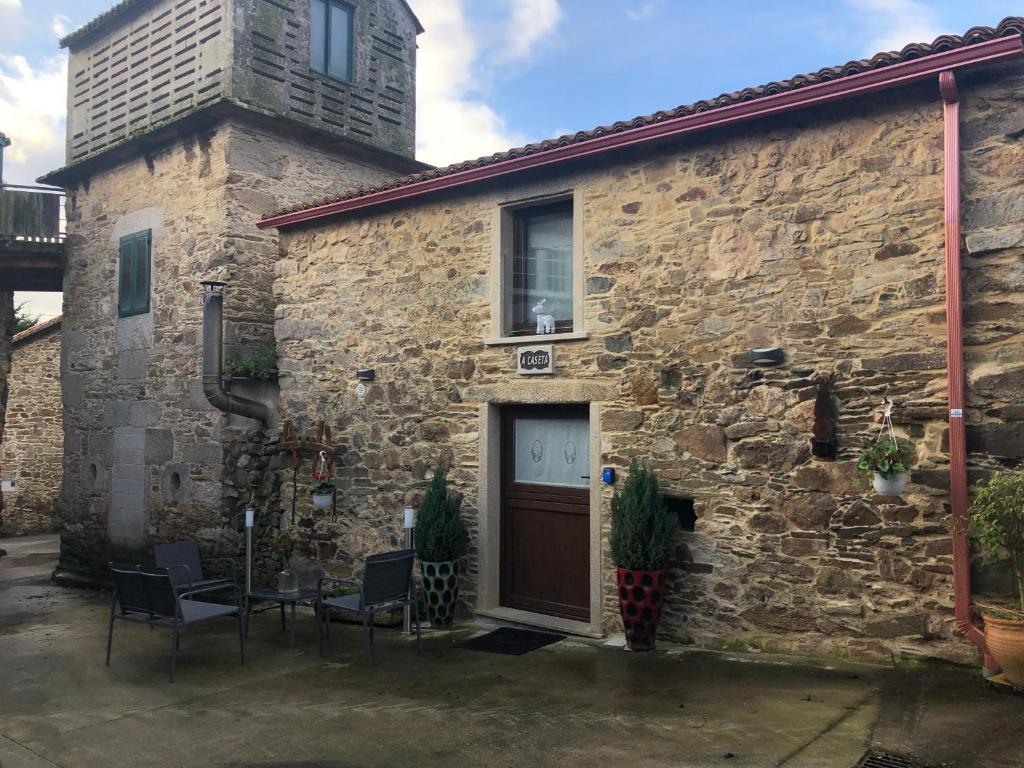 a stone building with a door and a window at A Caseta, en plena Costa da Morte in A Coruña