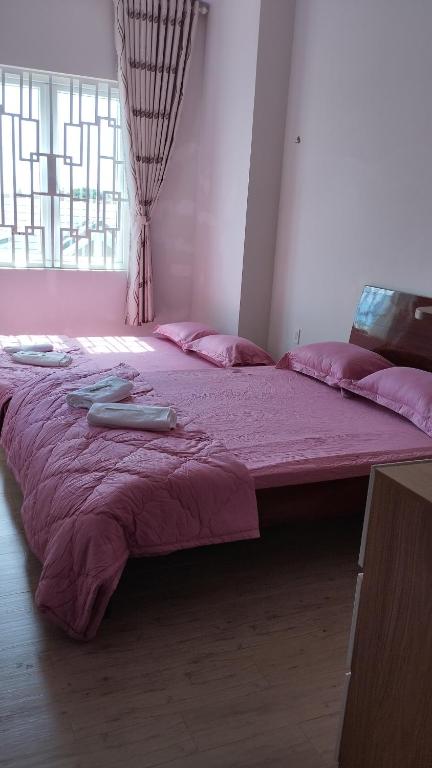 a large bed with pink sheets in a room at Trang Doan's homestay in Ấp Tân Bình (2)