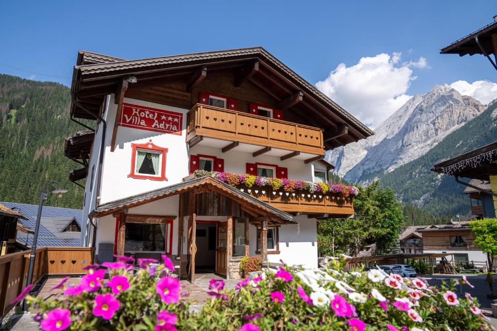 un edificio con dei fiori davanti di Villa Adria B&B a Canazei