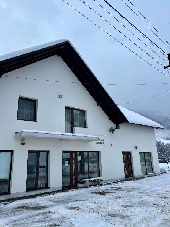 a white building with snow on the roof at Casa Vera in Vidra
