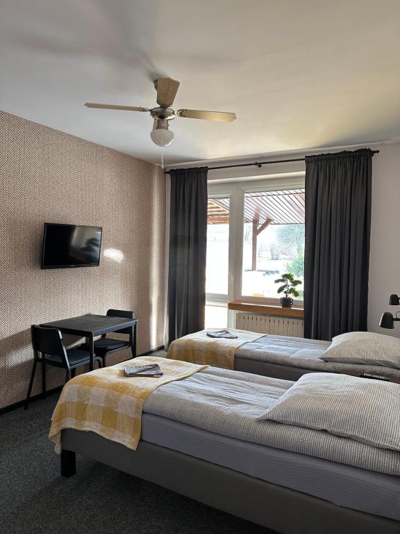 sypialnia z 2 łóżkami, stołem i oknem w obiekcie Zajazd Irina w mieście Białystok