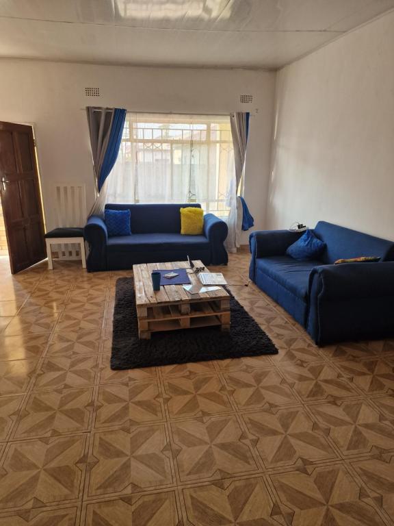 a living room with blue couches and a coffee table at Salama House in Lusaka