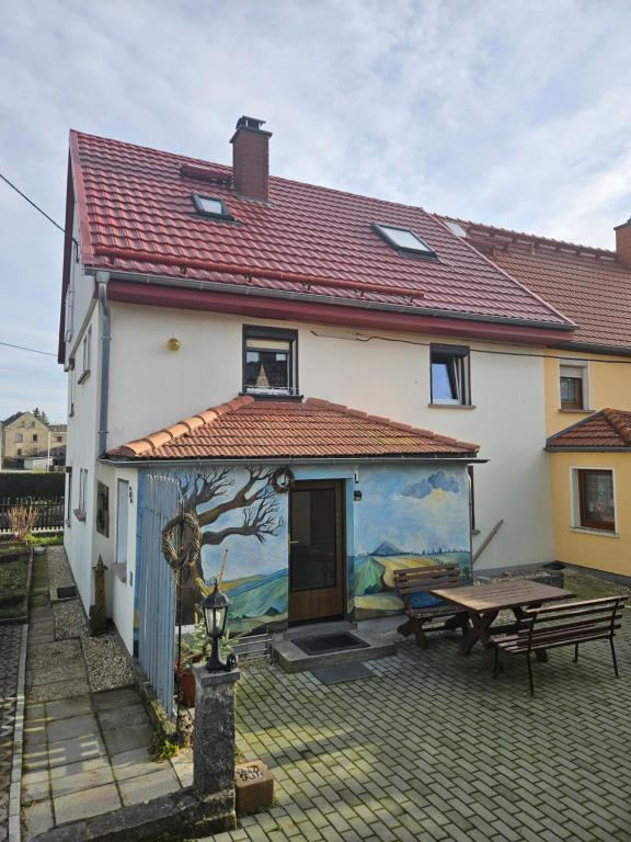 ein Haus mit einem Gemälde auf der Seite in der Unterkunft "Ruhige Naturlage im Wald" Ferienhaus mit Sauna in Großnaundorf