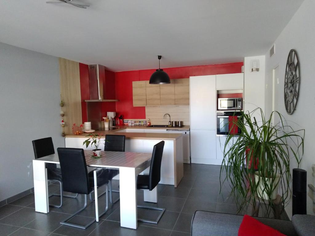 - une cuisine avec une table et des chaises dans la chambre dans l'établissement Beau T3 + clim + parking Saint Cyr sur mer, à Saint-Cyr-sur-Mer