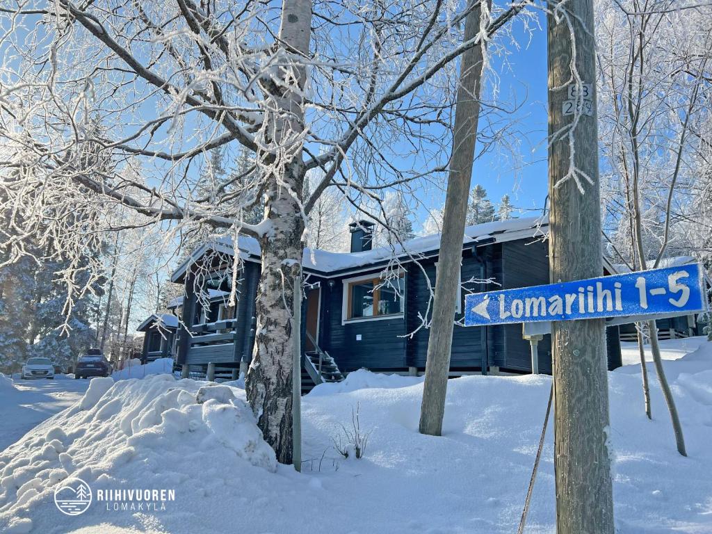 ein blaues Straßenschild im Schnee vor einem Haus in der Unterkunft Lomariihi 2 in Muurame