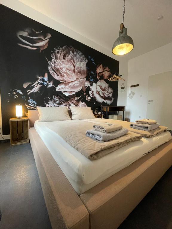 1 dormitorio con 1 cama grande con pared de flores en Schängelrooms, en Coblenza