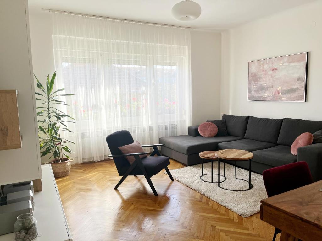 Apartman Cvjetnjak في تشاكوفيتش: غرفة معيشة مع أريكة وطاولة