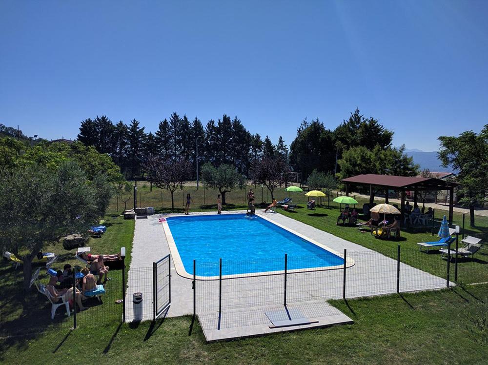 una grande piscina con persone sedute intorno di Agriturismo Alta Collina a Benevento