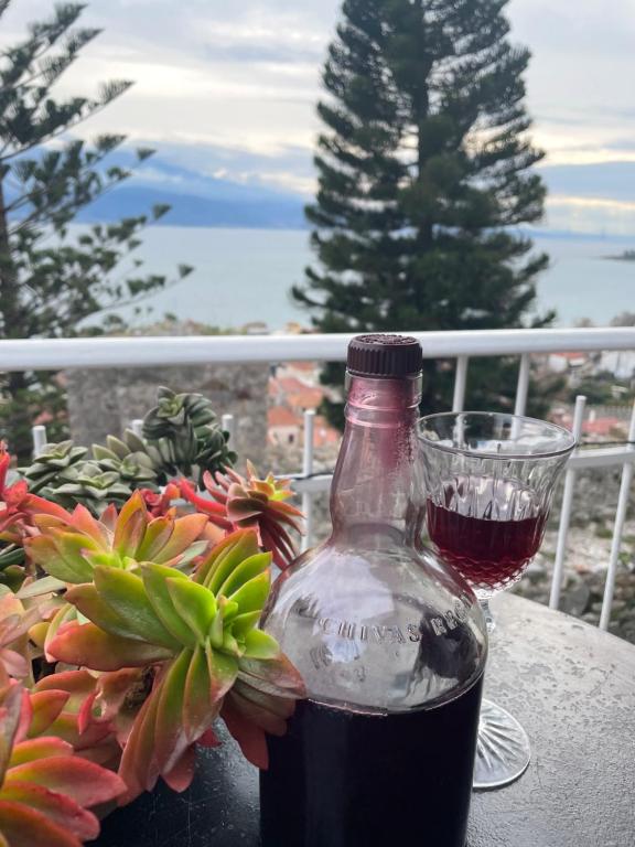 eine Flasche Wein auf einem Tisch mit einem Glas in der Unterkunft Sideroporta castle Náfpaktos in Nafpaktos