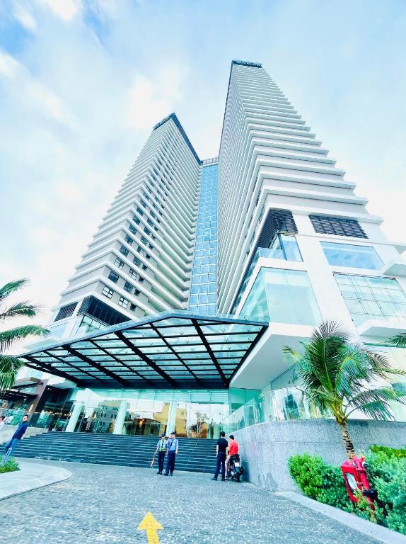 a group of people standing in front of a tall building at FLC Luxury Apartment Quy Nhon in Quy Nhon