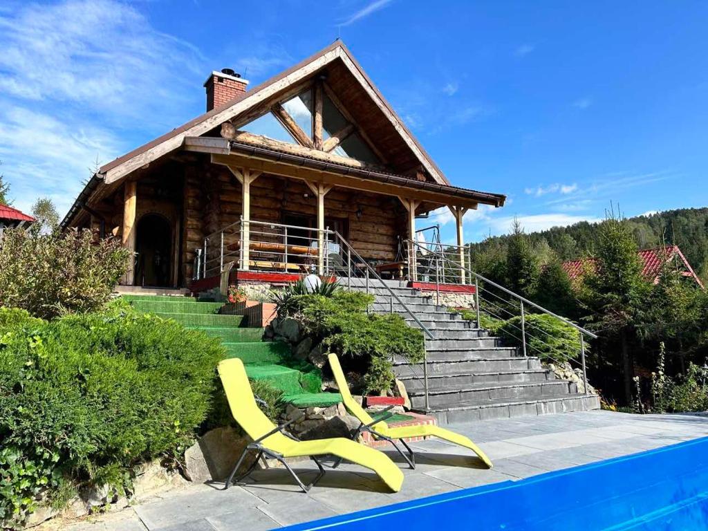 una casa con piscina y 2 sillas amarillas en Pod Smrekami en Sól
