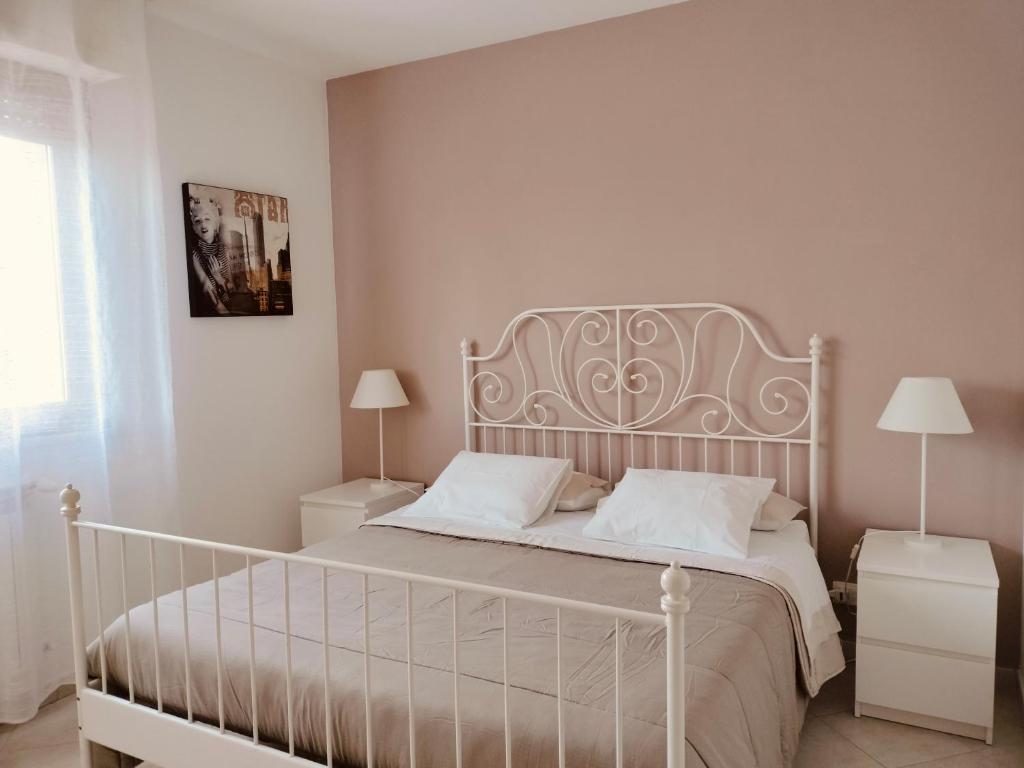 1 dormitorio con cama blanca y almohadas blancas en La casa di Ieia, en Porto Ercole