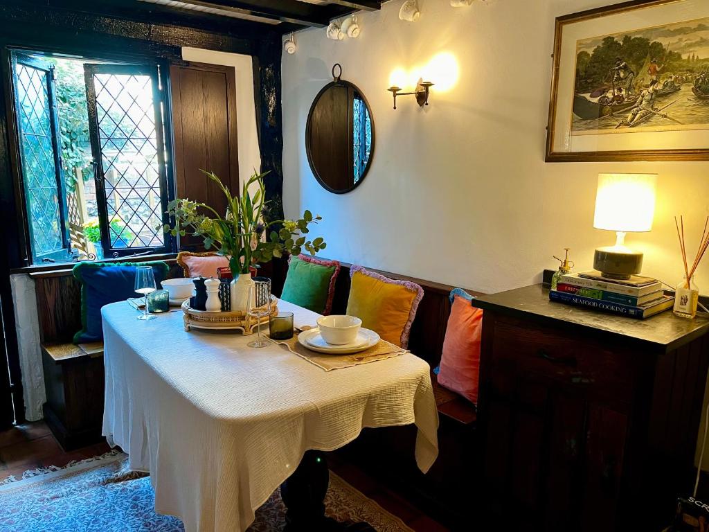 a room with a table with a white table cloth at 15th century tiny character cottage-Henley centre in Henley on Thames