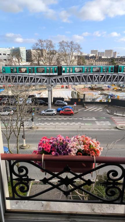 a train on a bridge over a parking lot with flowers at Austerlitz Cocoon in Paris