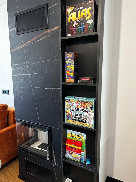 a black book shelf filled with games at Apartment Aurora in Bjelašnica