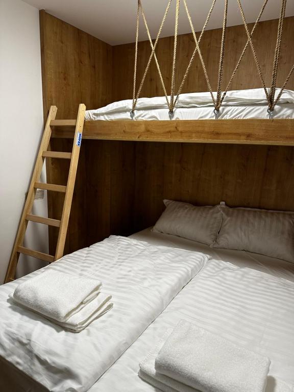 a bedroom with two bunk beds and a ladder at Apartment Aurora in Bjelašnica