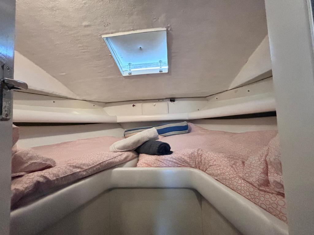 a small bed in a small room with a window at Wonderful boat for families and friends in Barcelona