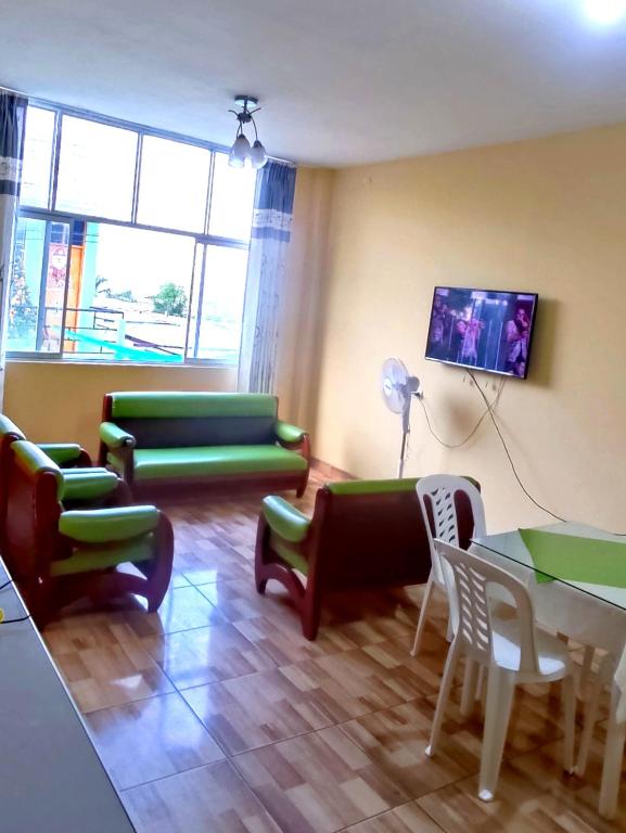 a living room with green furniture and a table at Departamento de Pablito Junto al Mar in Caleta Cruz
