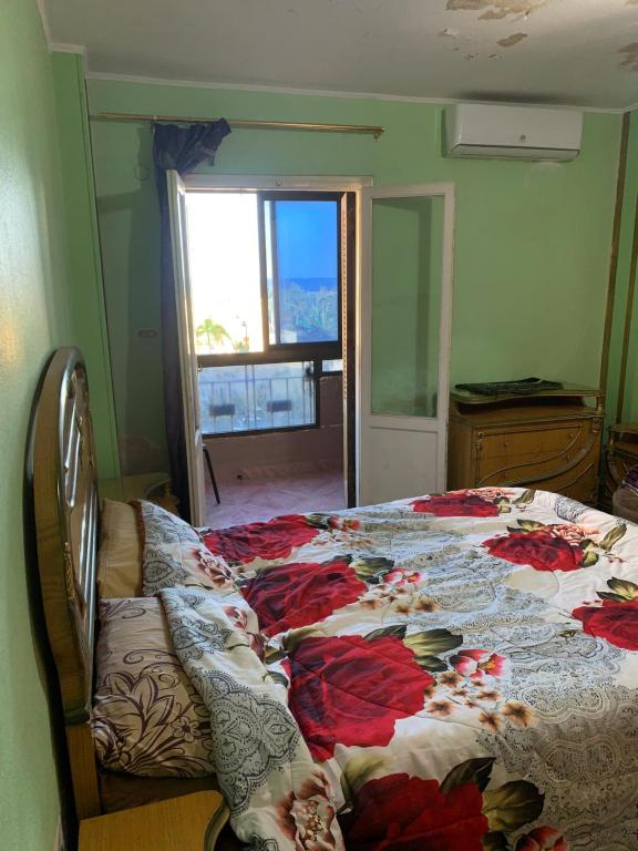 sypialnia z łóżkiem z narzutą kwiatową w obiekcie شقة 2 غرفة كبيرة ترى البحر مباشر مكيفة وسط المدينة w mieście Port Said