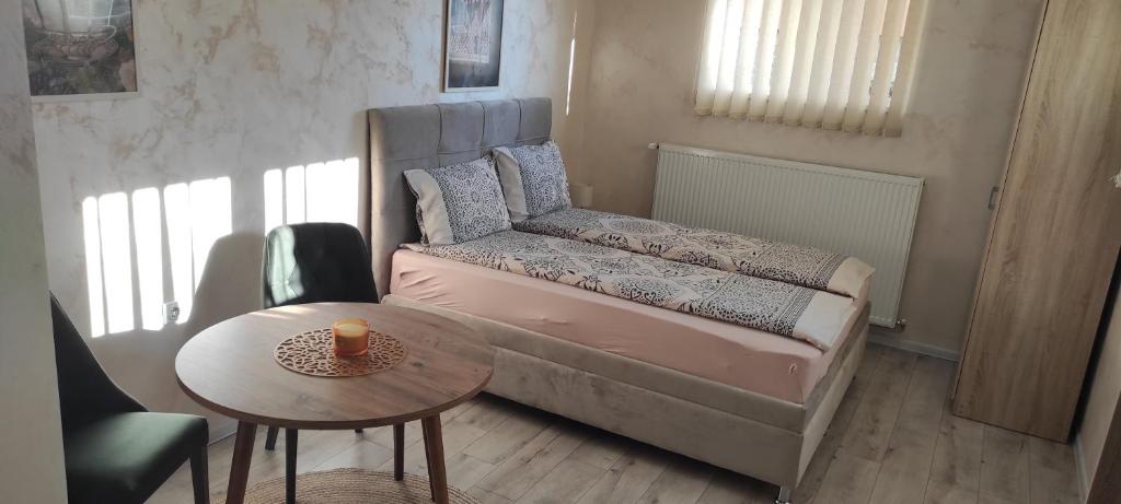 a small bedroom with a bed and a table at Apartment Flora Arandjelovac in Arandjelovac