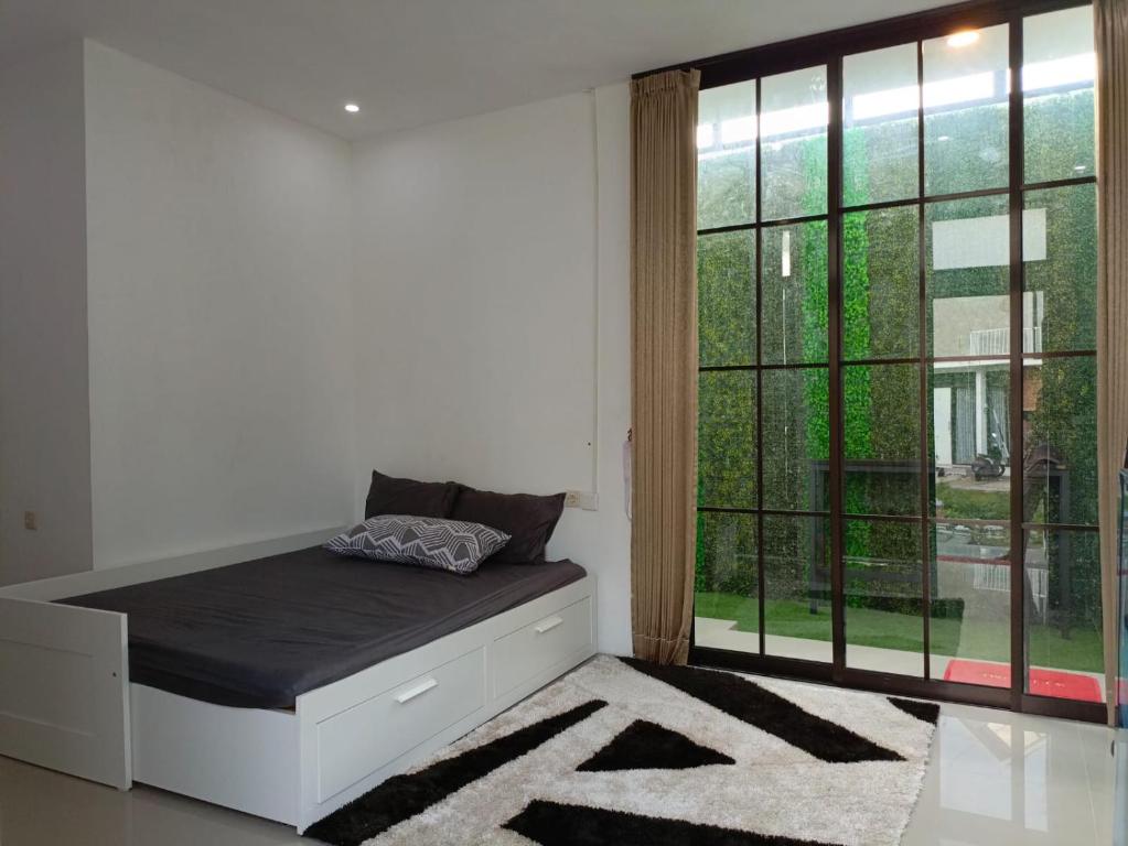 a bedroom with a bed and a large window at Orange house Villa in Dau