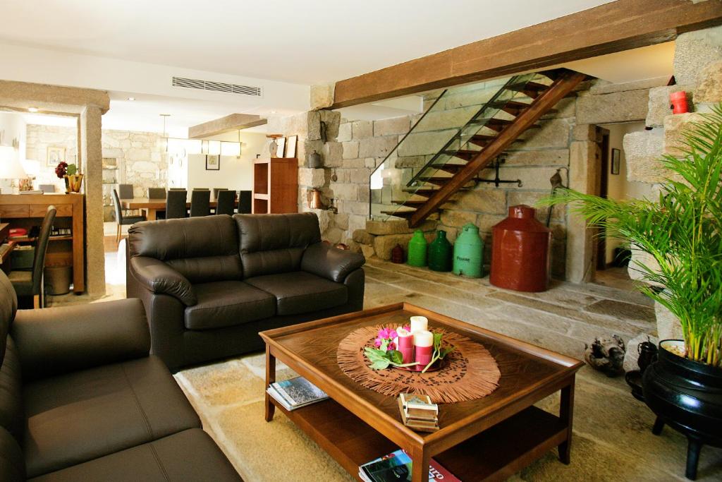 uma sala de estar com um sof e uma mesa em Casa Dos Poos em Vilar Torpim