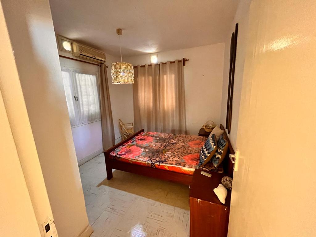 1 dormitorio con cama y ventana en Sulas Beach House, en Nampula