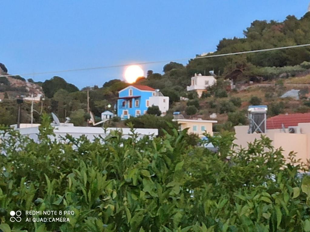 een huis op een heuvel met de zon op de achtergrond bij Blue Villa in Kalymnos