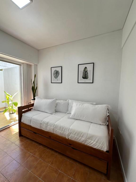 - un lit dans une chambre avec 2 photos sur le mur dans l'établissement Amplio Departamento en Zona Gastronómica a una cuadra de la Playa, à Mar del Plata