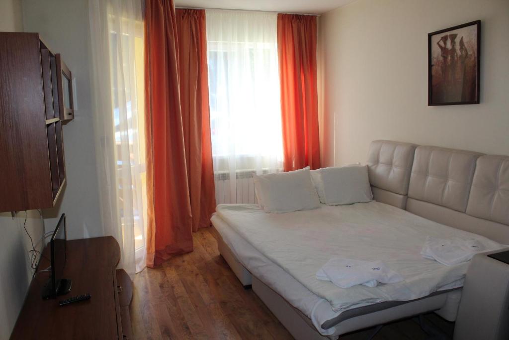 a small bedroom with a bed and a window at PM Services Royal Plaza Apartments in Borovets