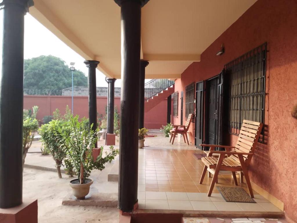 une terrasse couverte d'un bâtiment avec des chaises et des plantes dans l'établissement Villa 28, à Lomé