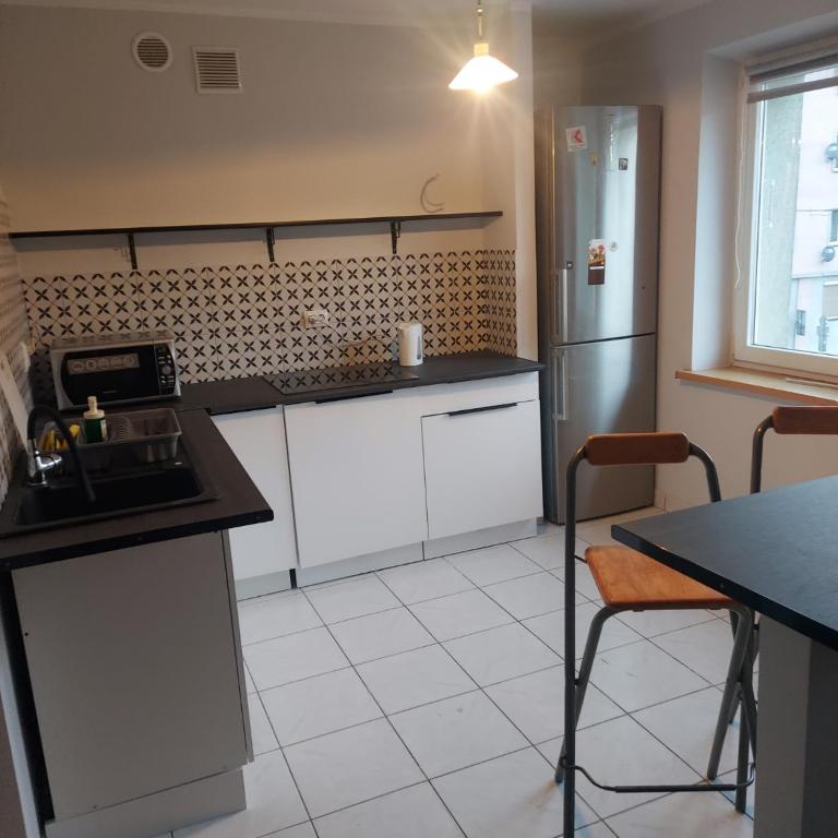 a kitchen with a counter and a refrigerator at Night Host in Bytom