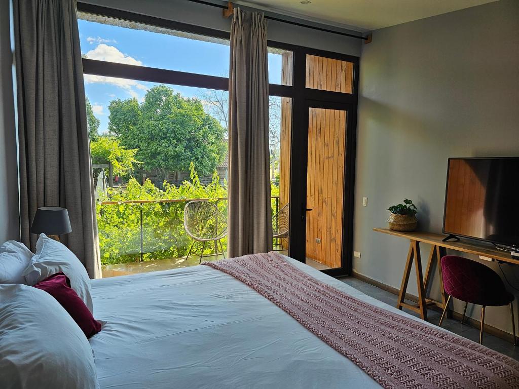 a bedroom with a bed and a large window at Parronales de Los Boldos in Santa Cruz