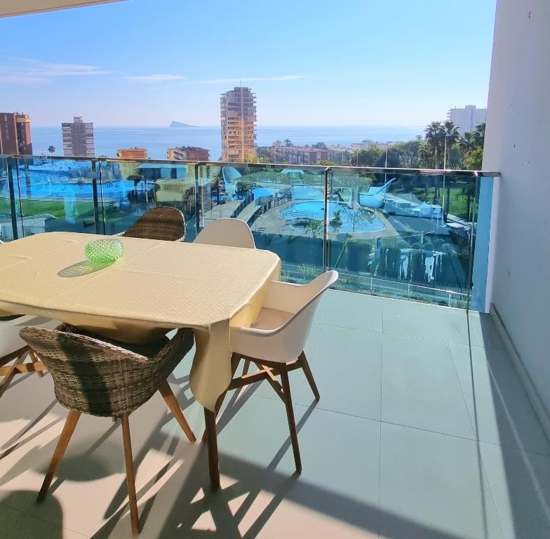 a table and chairs on a balcony with a view of the water at Sunset Drive Apartments in Benidorm