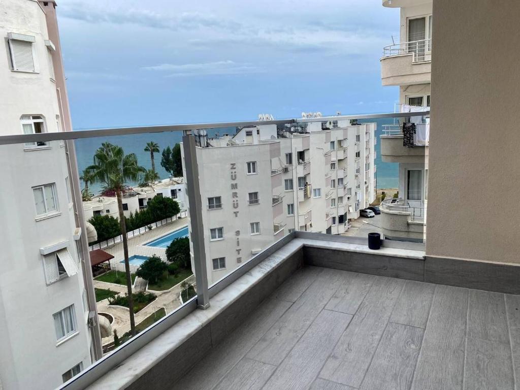 balcón con vistas a la playa y a los edificios en Sahil One bedroom Apartment, en Mezitli