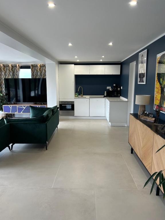 a living room with a green couch and a kitchen at A Eze , Bas de villa piscine près de Monaco in Èze